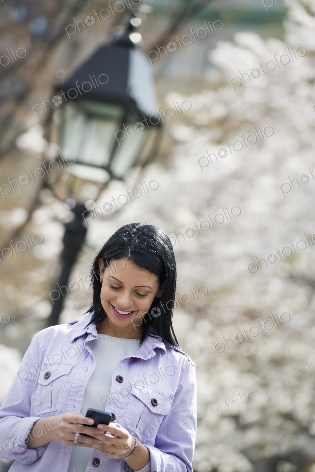 Outdoors in the city in spring time. New York City park. White blossom on the trees. A…