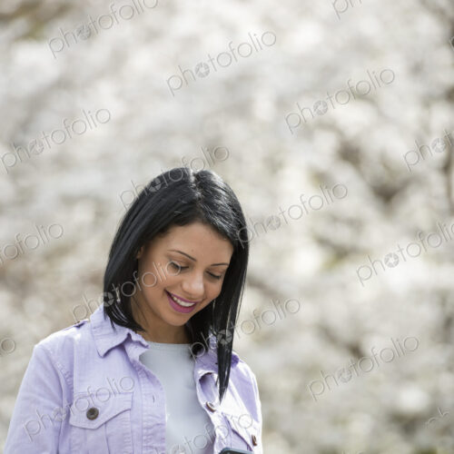 Outdoors in the city in spring time. New York City park. White blossom on the trees. A…