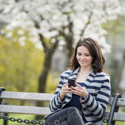 Outdoors in the city in spring time. New York City park. White blossom on the trees. A…