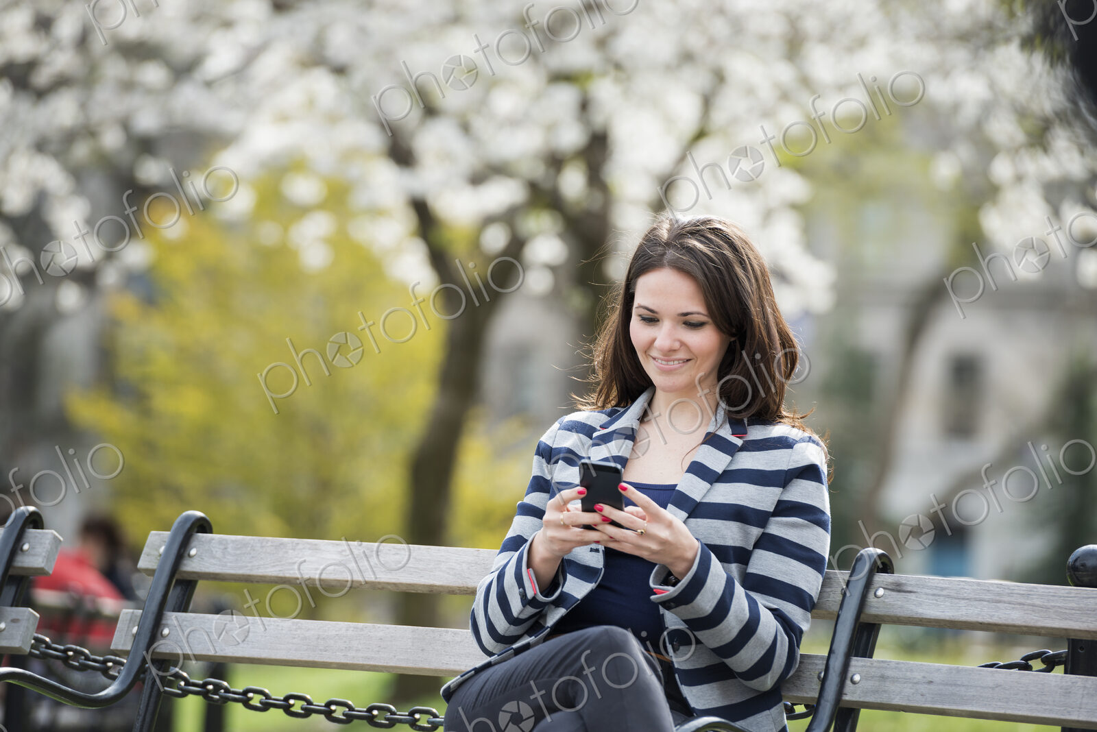 Outdoors in the city in spring time. New York City park. White blossom on the trees. A…