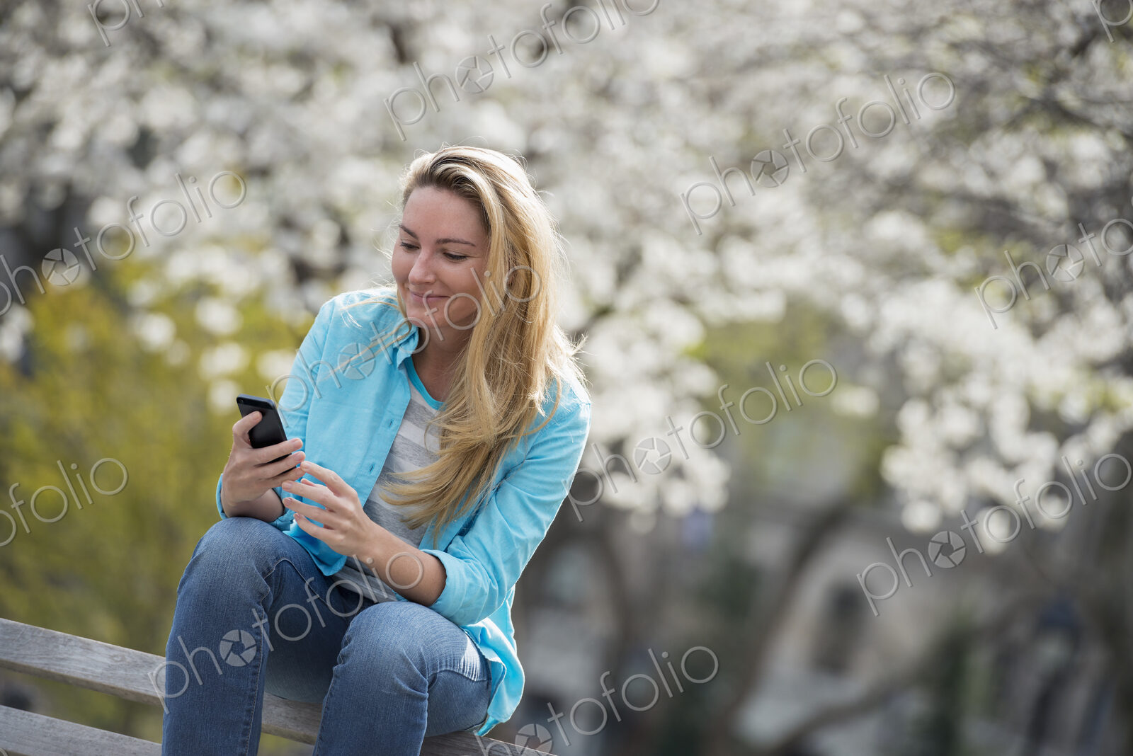 Outdoors in the city in spring time. New York City park. White blossom on the trees. A…