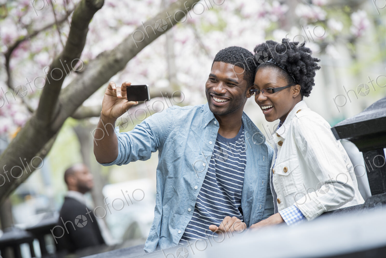 Outdoors in the city in spring. An urban lifestyle. A couple side by side, cheek to…
