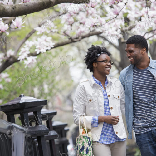 Outdoors in the city in spring. An urban lifestyle. A couple walking in the park side…
