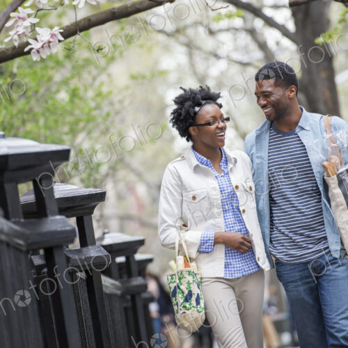 Outdoors in the city in spring. An urban lifestyle. A couple walking in the park side…
