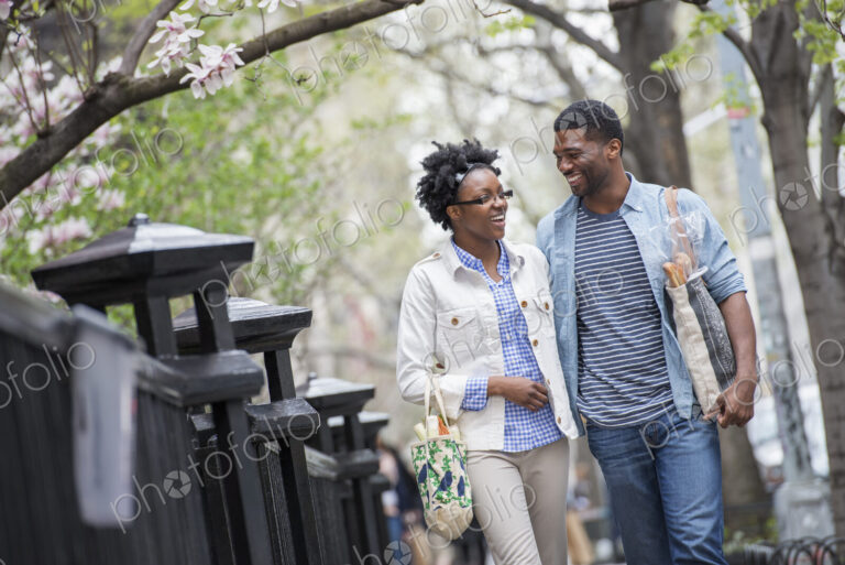 Outdoors in the city in spring. An urban lifestyle. A couple walking in the park side…