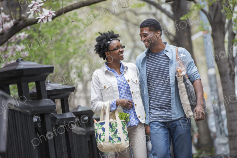 Outdoors in the city in spring. An urban lifestyle. A couple walking in the park side…
