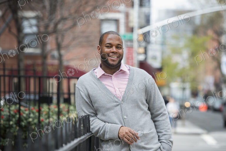 Outdoors in the city in spring. An urban lifestyle. A man leaning against a railing…
