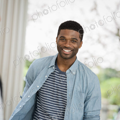 Outdoors in the city in spring. An urban lifestyle. A man looking at the camera, with…