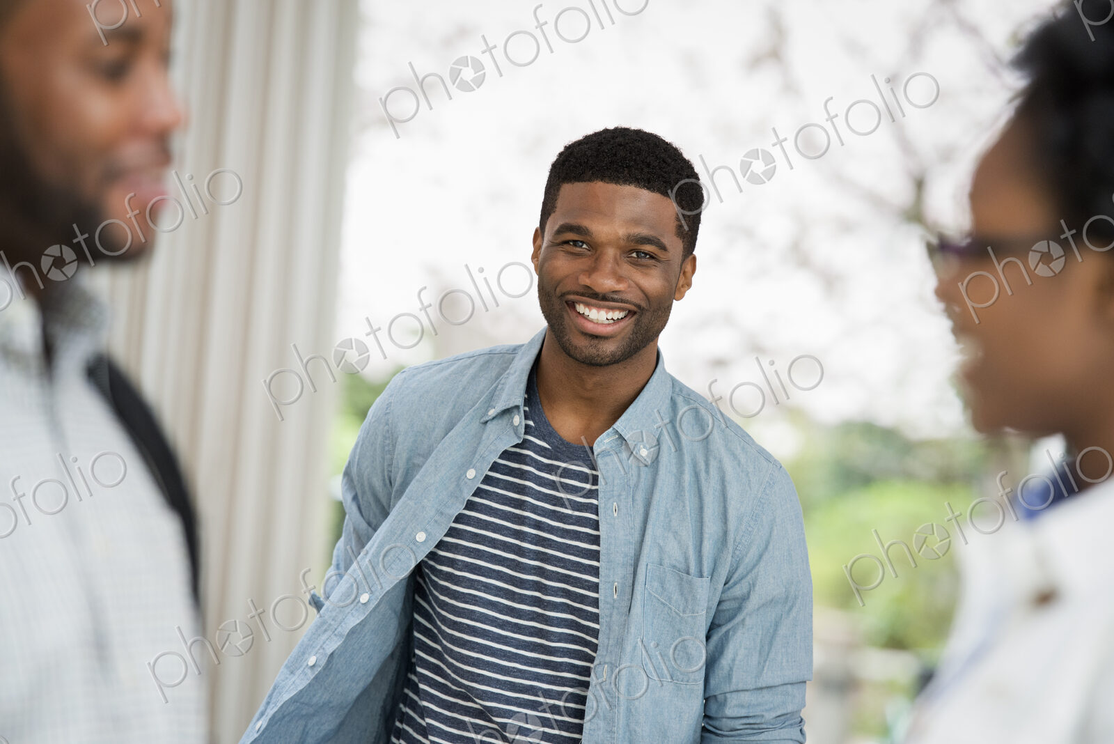 Outdoors in the city in spring. An urban lifestyle. A man looking at the camera, with…
