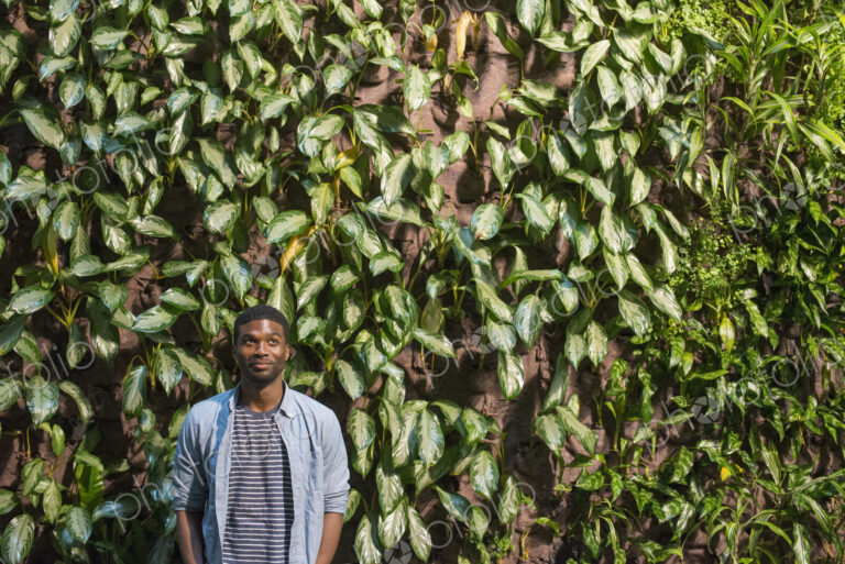 Outdoors in the city in spring. An urban lifestyle. A man standing in front of a wall…