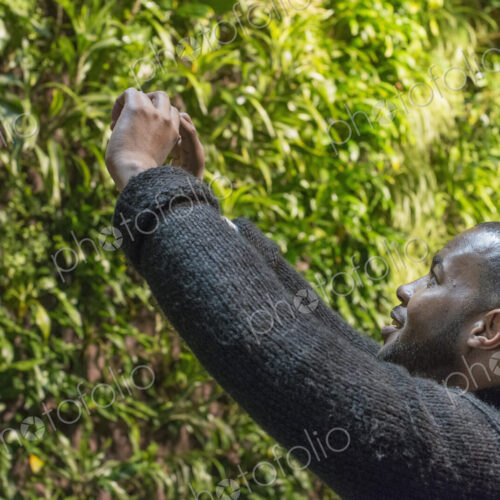 Outdoors in the city in spring. An urban lifestyle. A man taking an image on his… Outdoors in the city in spring. An urban lifestyle. A man taking an image on his…