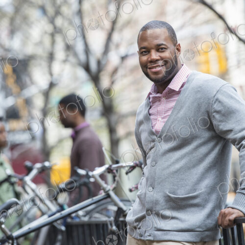 Outdoors in the city in spring. An urban lifestyle. A man using his phone. A group of… Outdoors in the city in spring. An urban lifestyle. A man using his phone. A group of…
