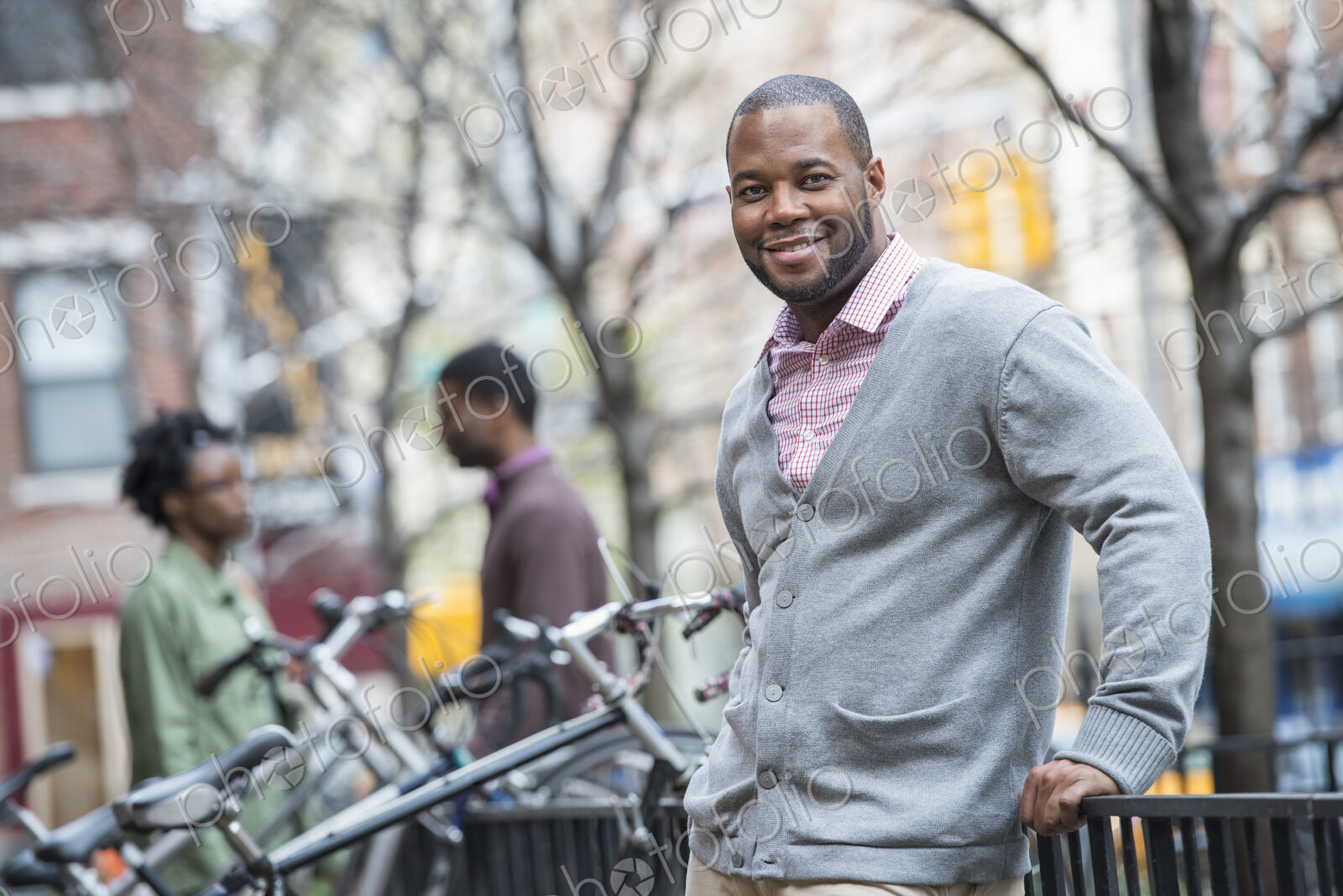 Outdoors in the city in spring. An urban lifestyle. A man using his phone. A group of…