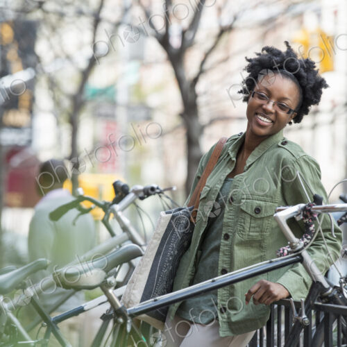 Outdoors in the city in spring. An urban lifestyle. A woman leaning against a railing…