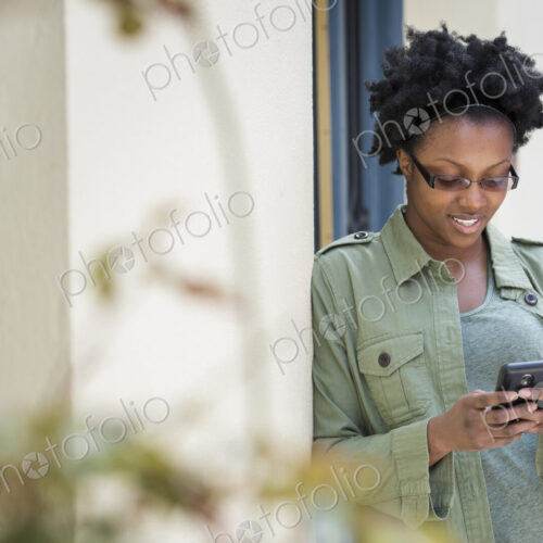 Outdoors in the city in spring. An urban lifestyle. A woman leaning against a… Outdoors in the city in spring. An urban lifestyle. A woman leaning against a…