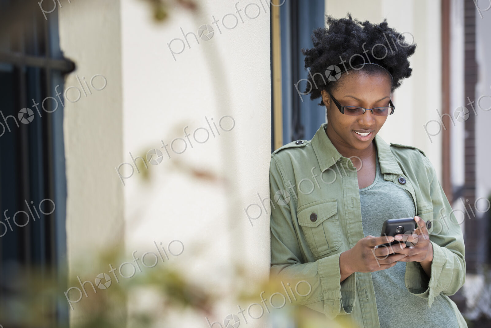 Outdoors in the city in spring. An urban lifestyle. A woman leaning against a…