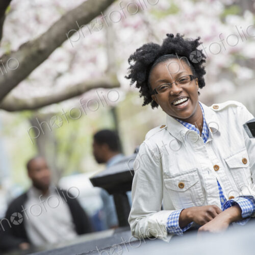 Outdoors in the city in spring. An urban lifestyle. A woman seated at a table with two… Outdoors in the city in spring. An urban lifestyle. A woman seated at a table with two…