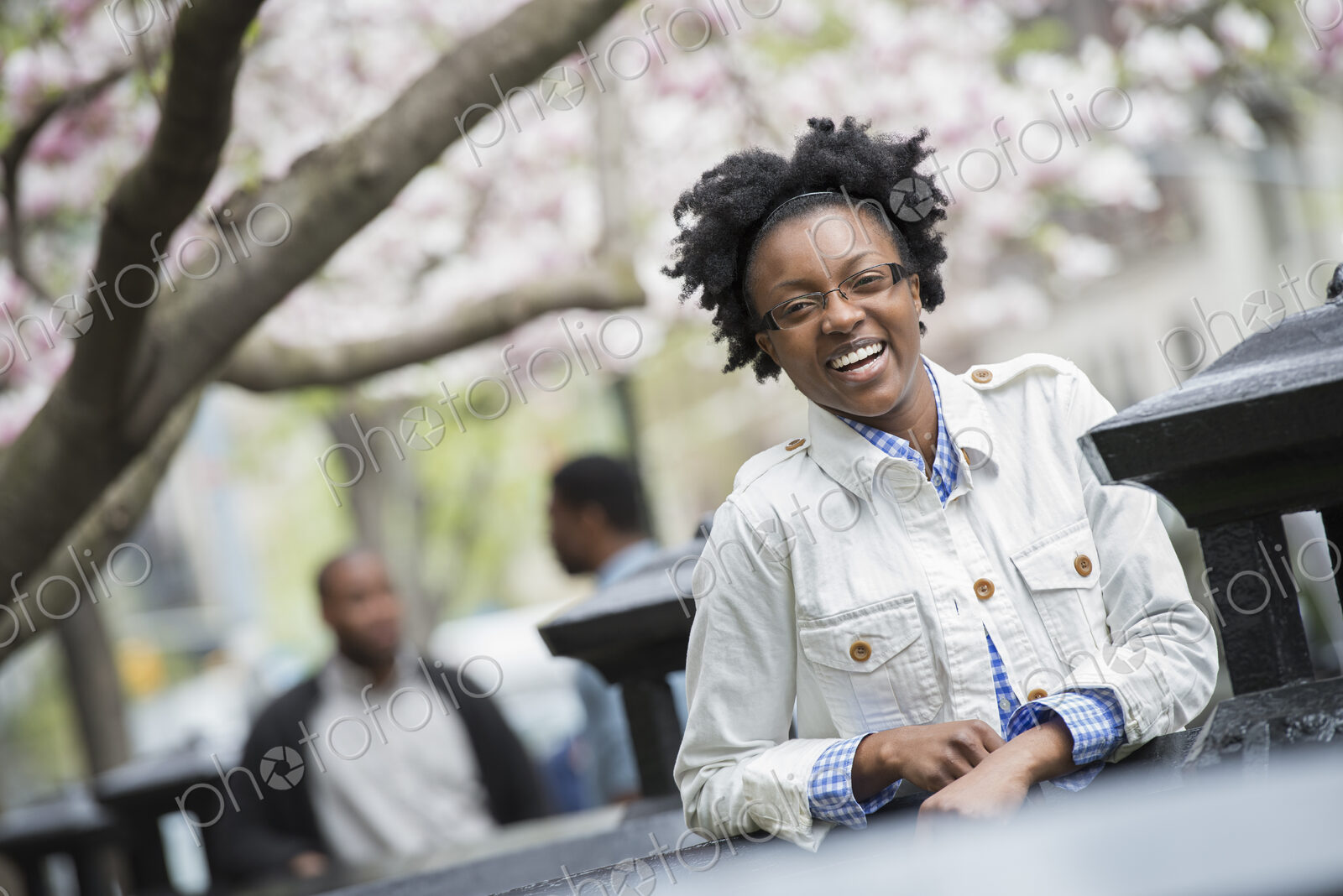 Outdoors in the city in spring. An urban lifestyle. A woman seated at a table with two…