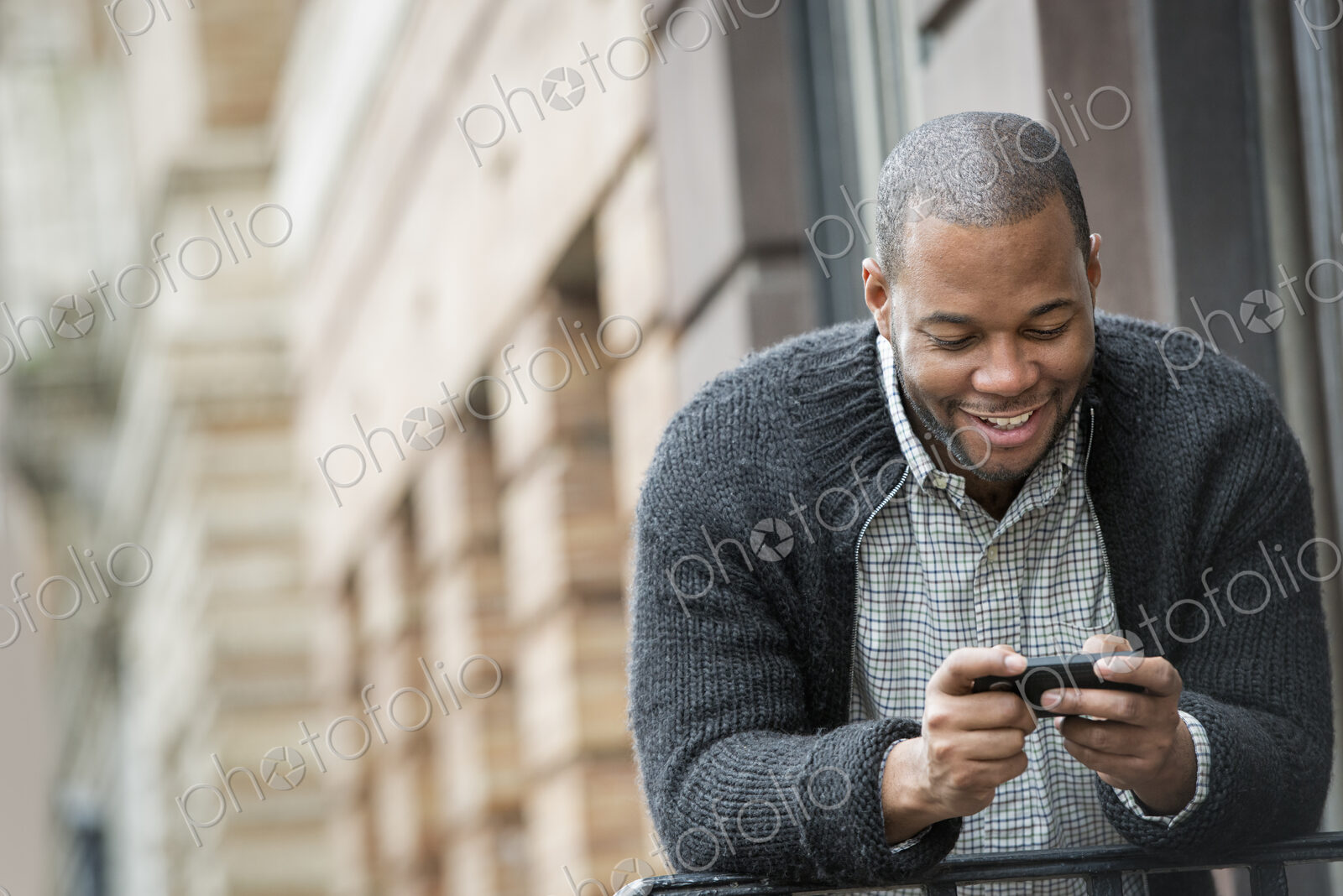 Outdoors in the city in spring. An urban lifestyle. A young man checking his phone and…