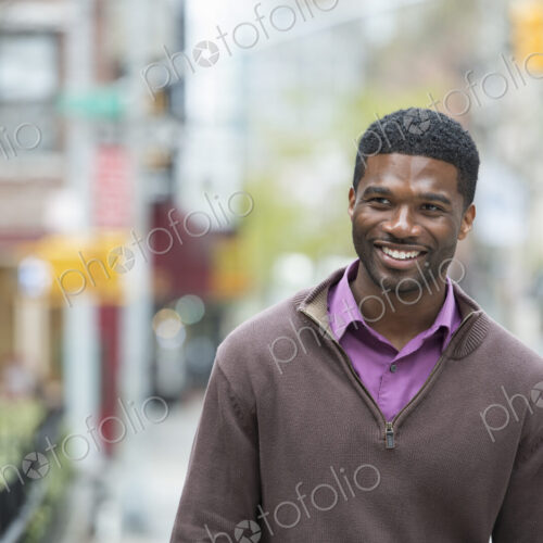 Outdoors in the city in spring. An urban lifestyle. A young man wearing a purple shirt…