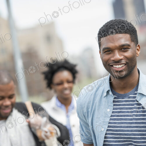 Outdoors in the city in spring. An urban lifestyle. Three people, a couple and a young…