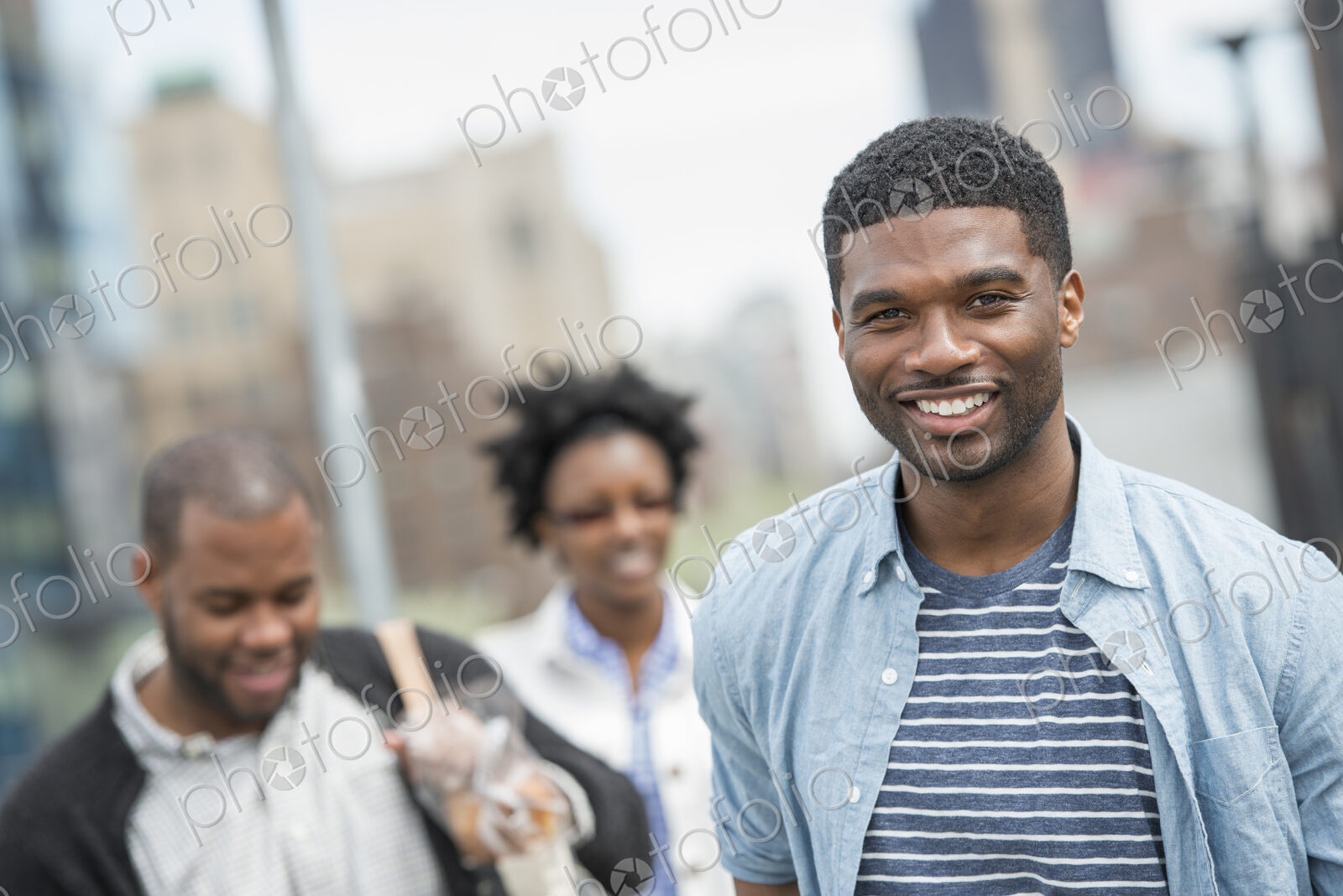 Outdoors in the city in spring. An urban lifestyle. Three people, a couple and a young…
