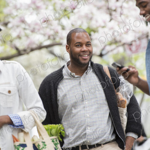 Outdoors in the city in spring. An urban lifestyle. Three people in the park. One man…