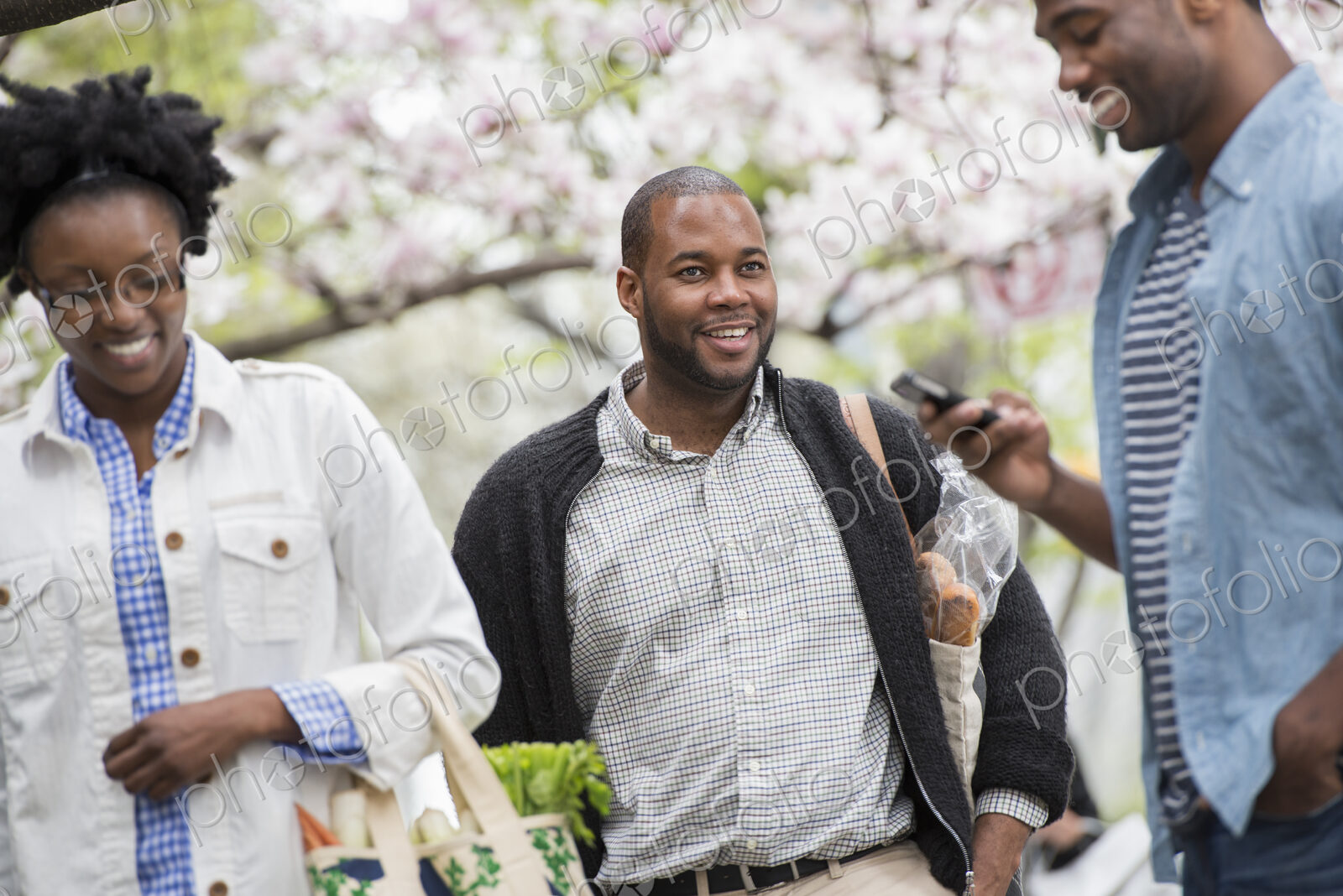 Outdoors in the city in spring. An urban lifestyle. Three people in the park. One man…