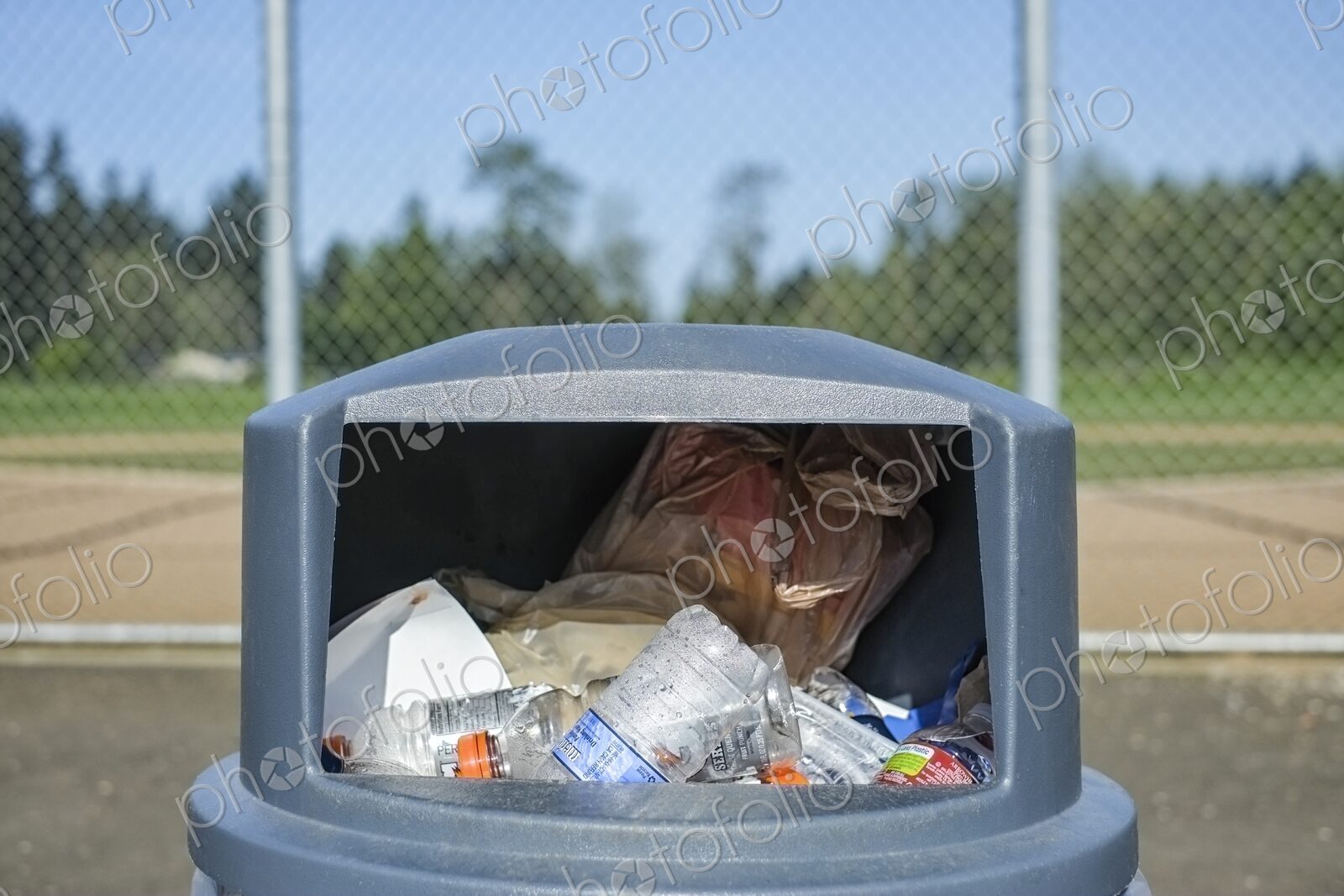 Overflowing trash in trashcan at sports field