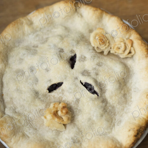 Overhead view of a freshly baked home made pie with pastry top and decoration. Overhead view of a freshly baked home made pie with pastry top and decoration.