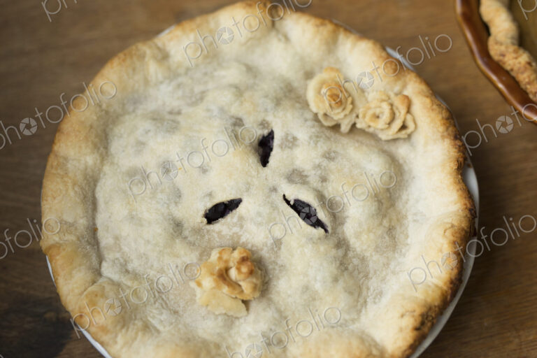 Overhead view of a freshly baked home made pie with pastry top and decoration.