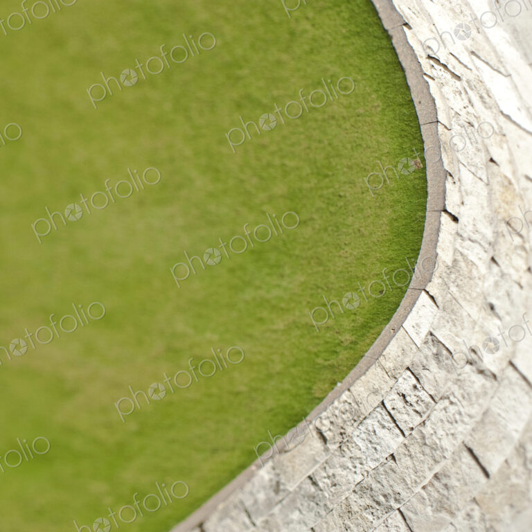 Overhead view of a green lawn and hard landscaping paving.