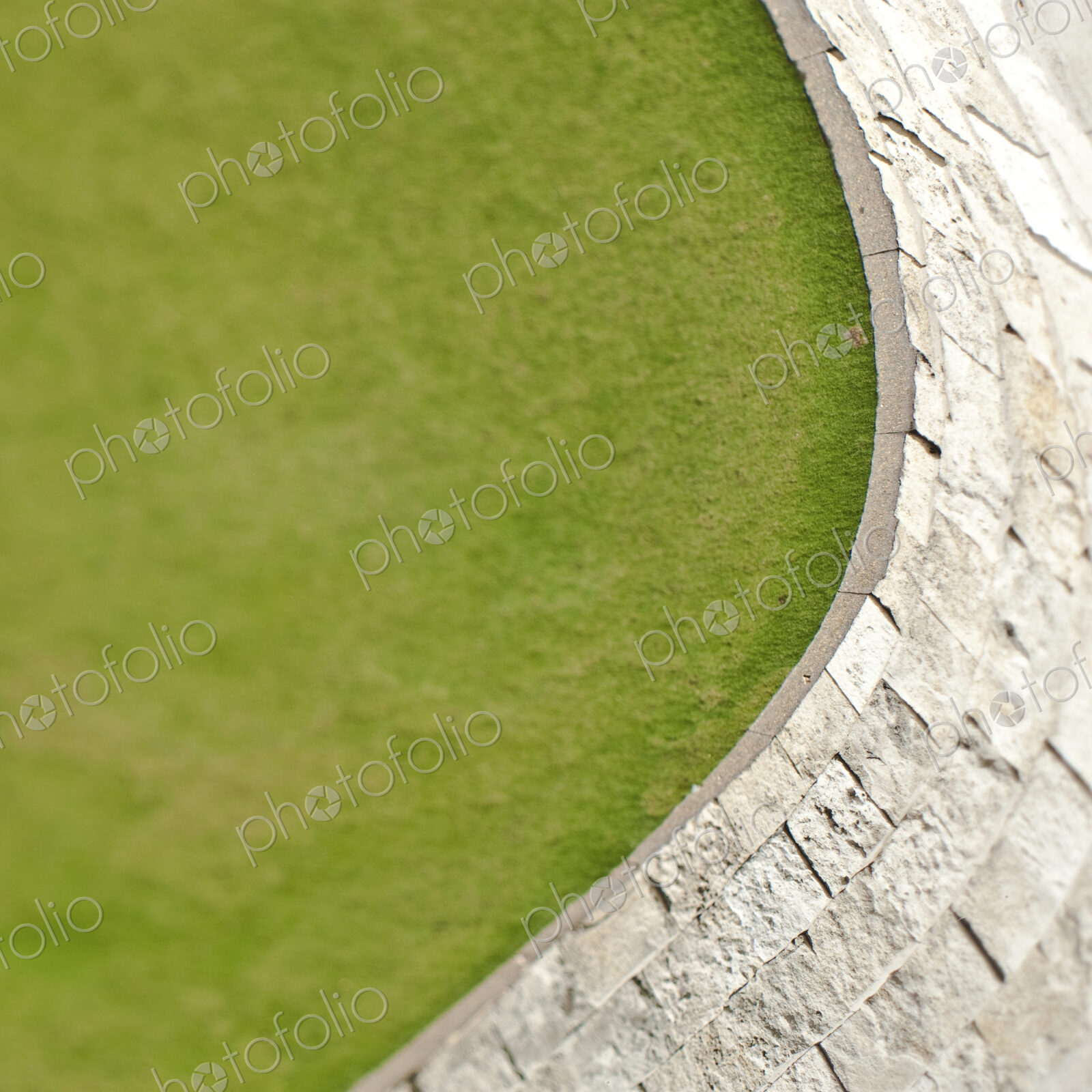 Overhead view of a green lawn and hard landscaping paving.