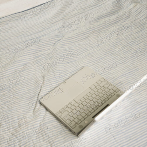 Overhead view of open laptop on bed.