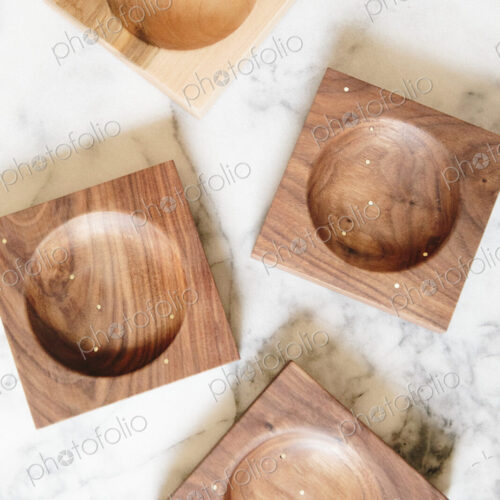 Overhead view of wood turned dishes on a marble background.