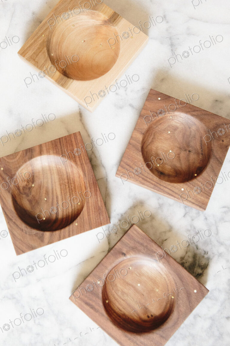 Overhead view of wood turned dishes on a marble background.