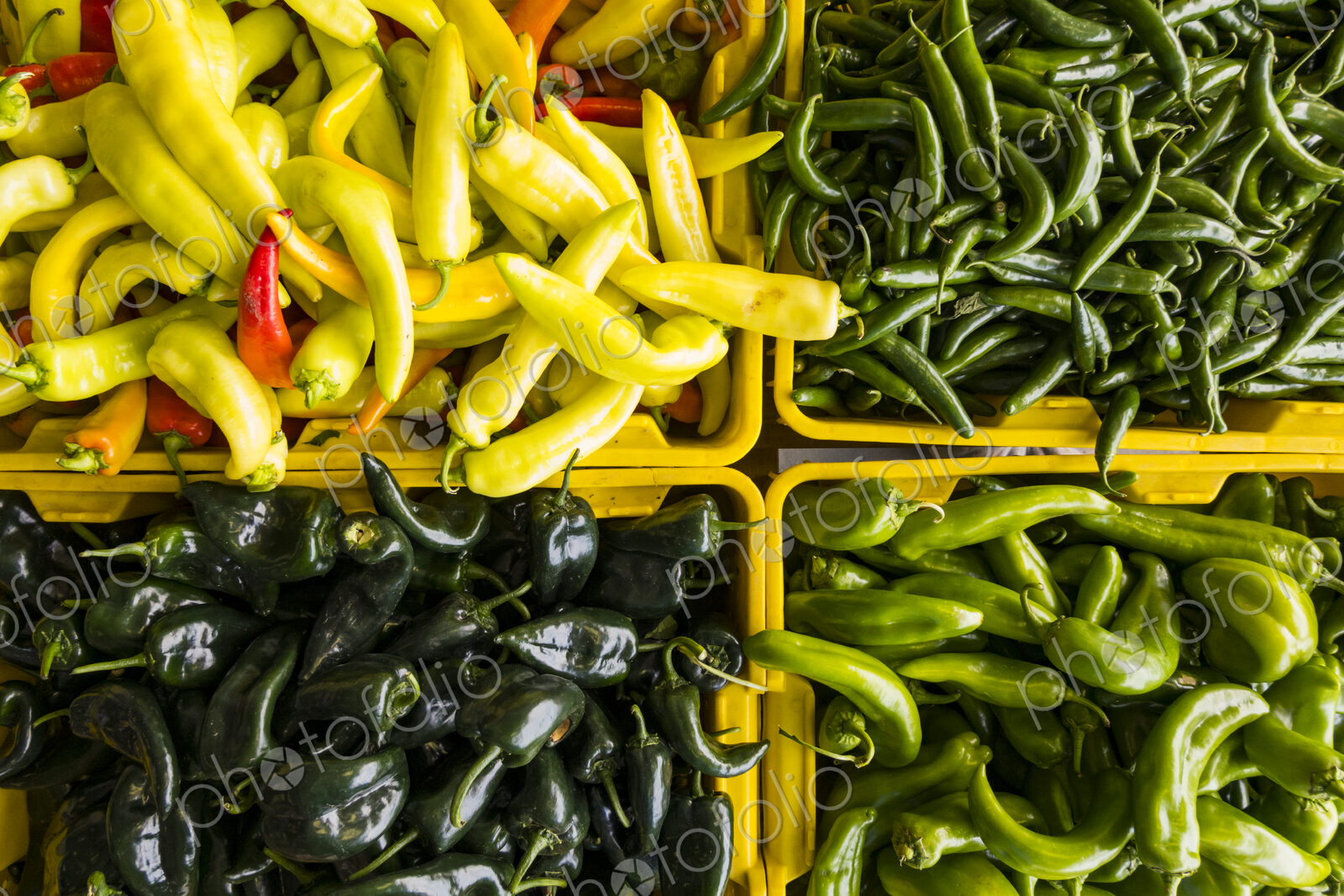 Overview of varieties of chili peppers on a market stall.