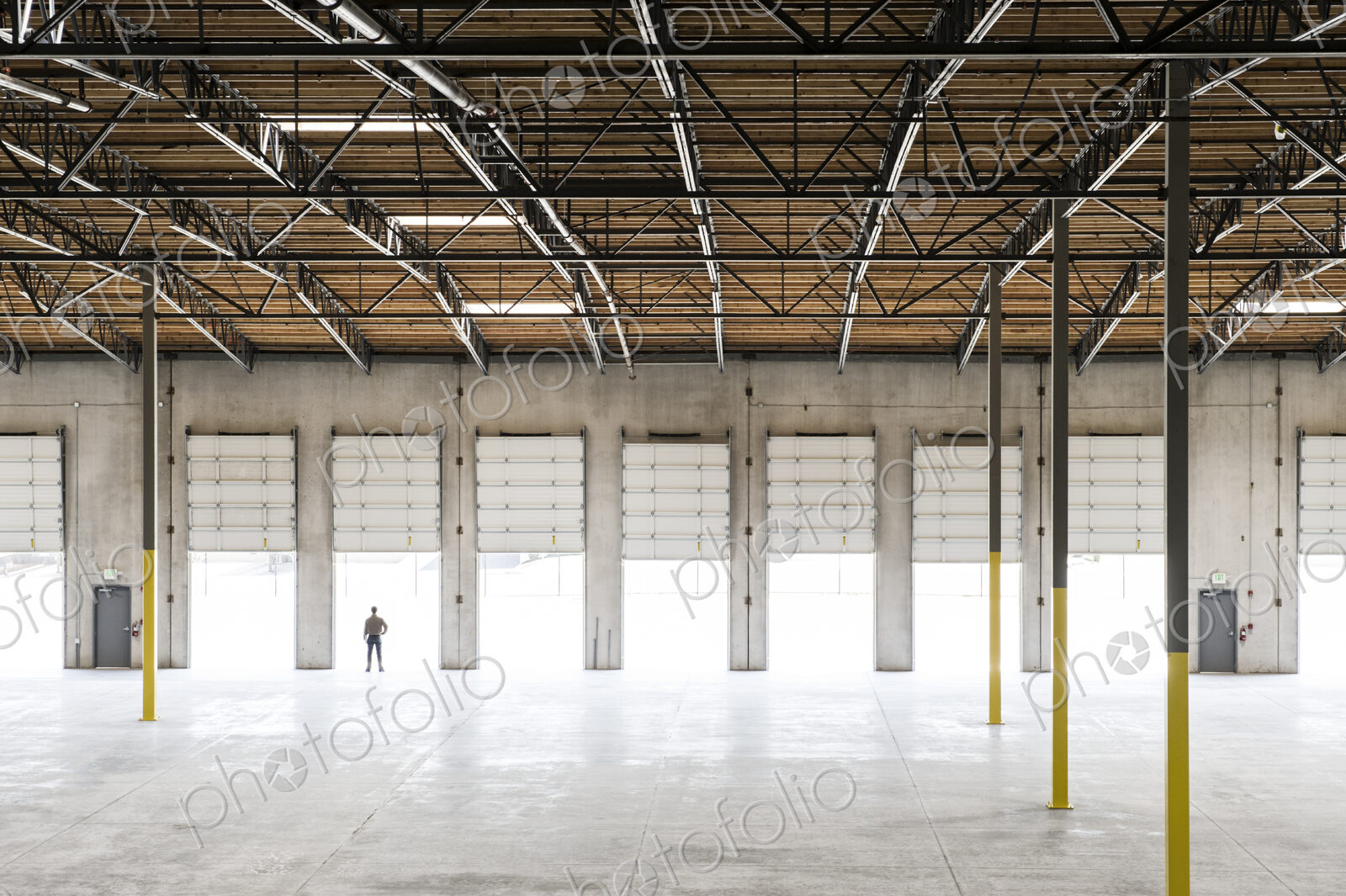 Owner silhouetted and standing in a loading dock door for a new empty warehouse.