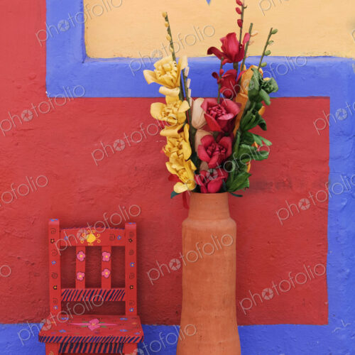 Painted chair next to vase with flowers, Chiapas, Mexico Painted chair next to vase with flowers, Chiapas, Mexico