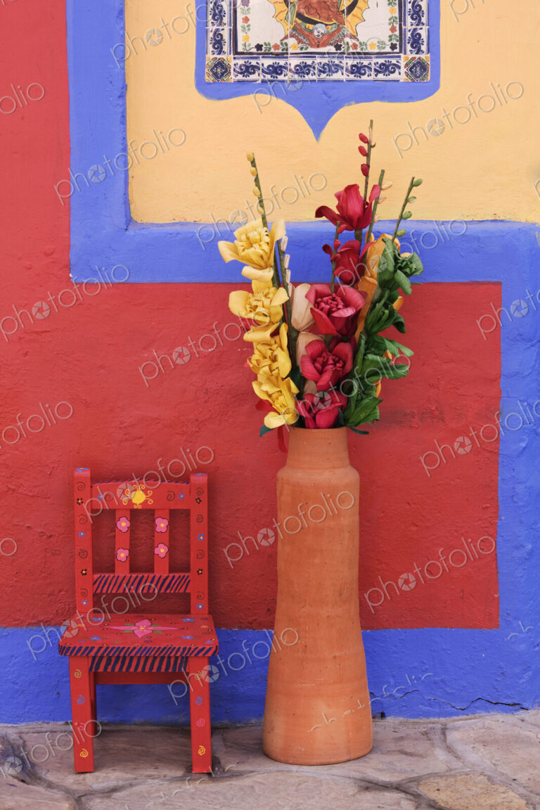 Painted chair next to vase with flowers, Chiapas, Mexico