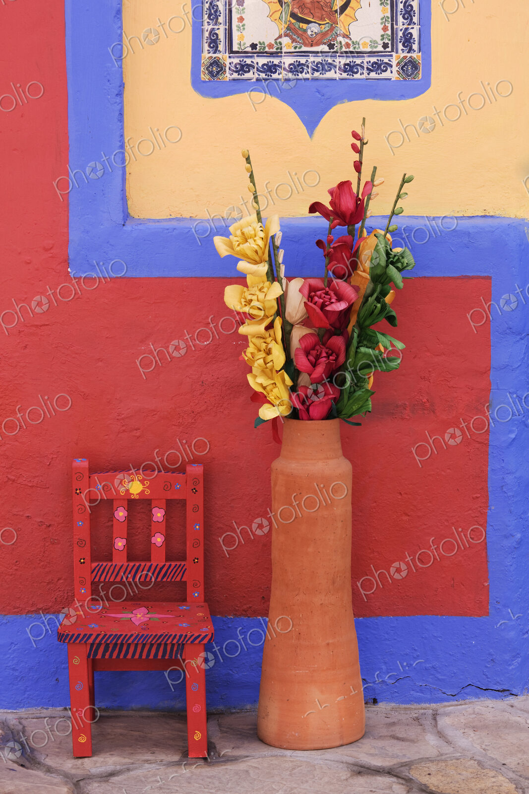 Painted chair next to vase with flowers, Chiapas, Mexico