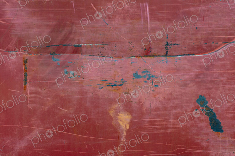 Painted red metal with rust and scratch markings