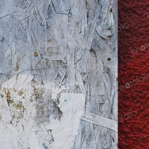 Painted white particle board against red stucco Painted white particle board against red stucco