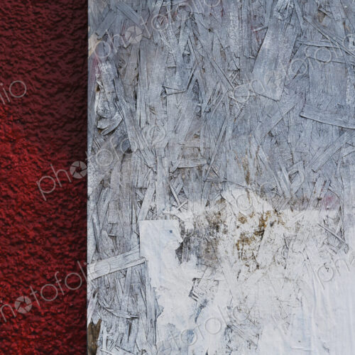 Painted white particle board against red stucco Painted white particle board against red stucco