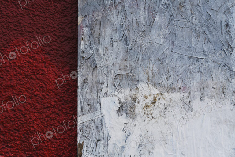 Painted white particle board against red stucco