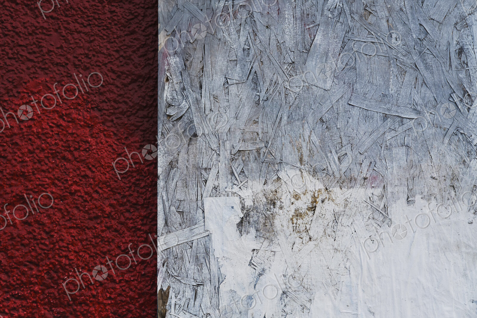 Painted white particle board against red stucco