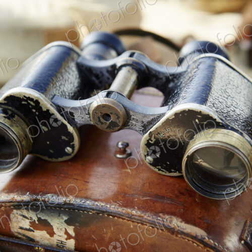 Pair of vintage binoculars with a worn leather case at a flea market.