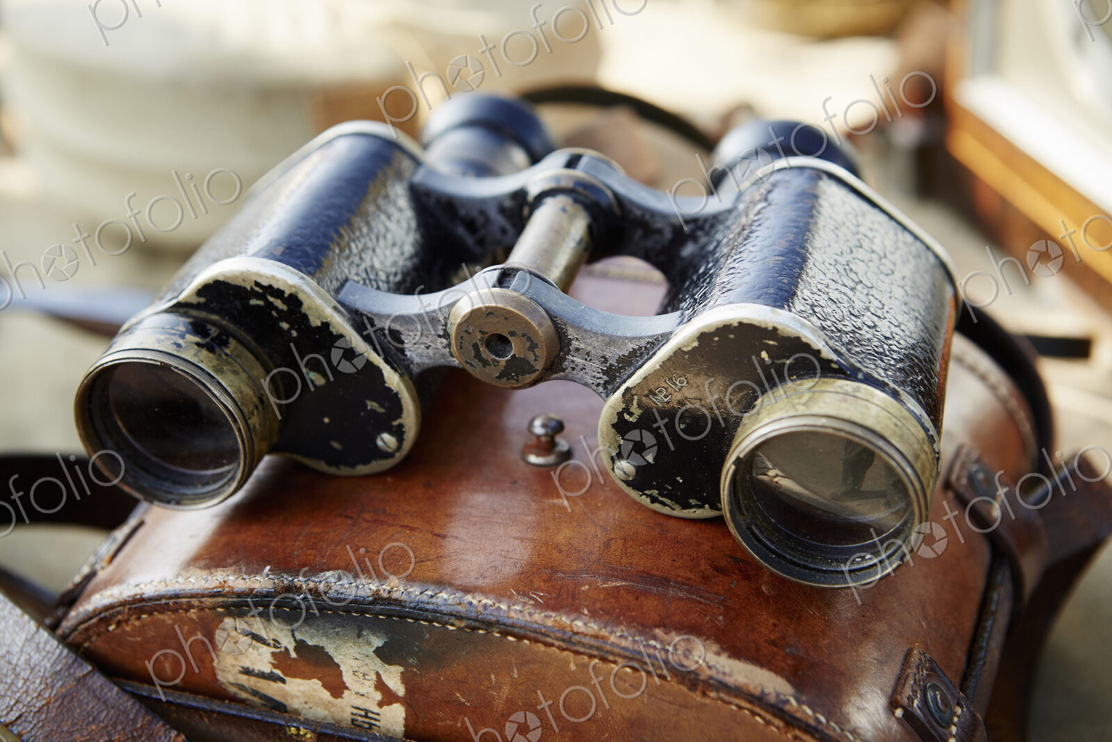 Pair of vintage binoculars with a worn leather case at a flea market.