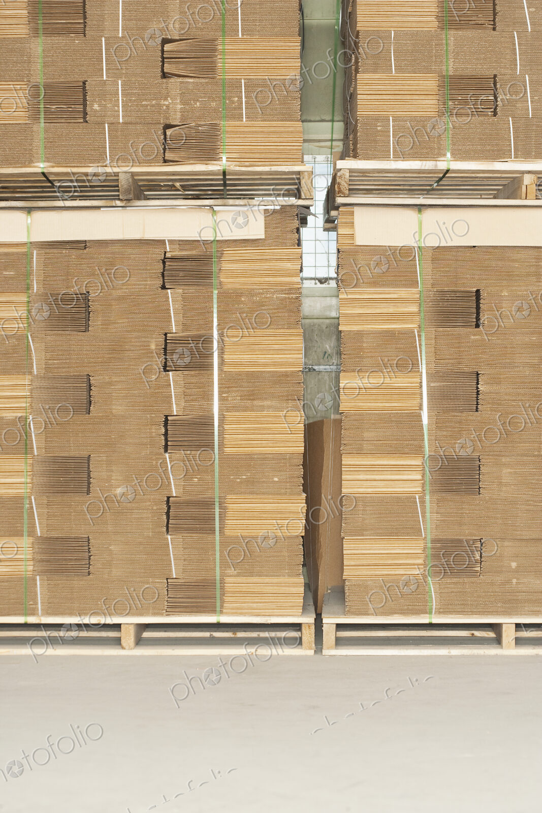 Pallets of flat folded cardboard boxes.