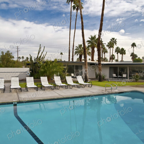 Palm Springs motel swimming pool and sun loungers with palm trees Palm Springs motel swimming pool and sun loungers with palm trees